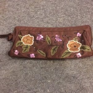 Embroidered brown clutch with celadon green interior.